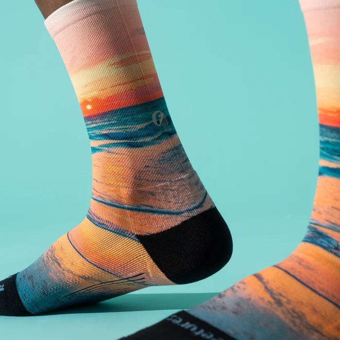Close-up of the sunset print and black heel on Feetures Elite Light Cushion Mini Crew socks in Sunset Glow