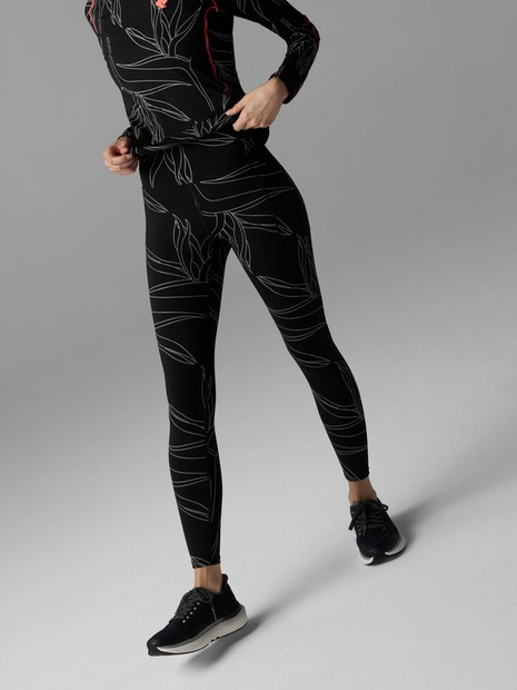 Woman stepping forward in Rabbit Low Light Speed Tights in Black Reflective with a matching top