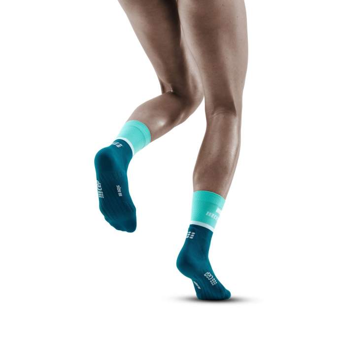 Run Compression Socks 4.0 Mid Cut - Women by CEP Sports in teal and navy, stabilizing joints with wrinkle-free medi compression for injury prevention during running