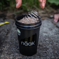 Protein Powder Chocolate by Naak in black shaker cup with high-protein powder for muscle recovery and hydration for endurance athletes