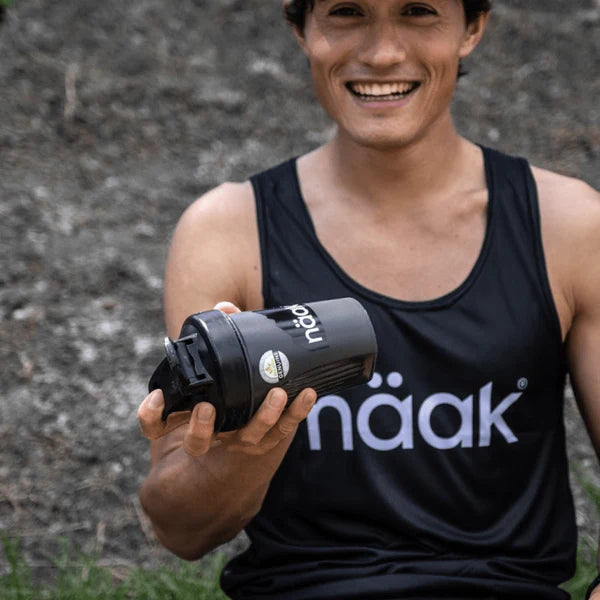 Protein Powder Vanilla by Näak in black shaker cup, high-protein recovery powder for endurance athletes to aid muscle building and hydration