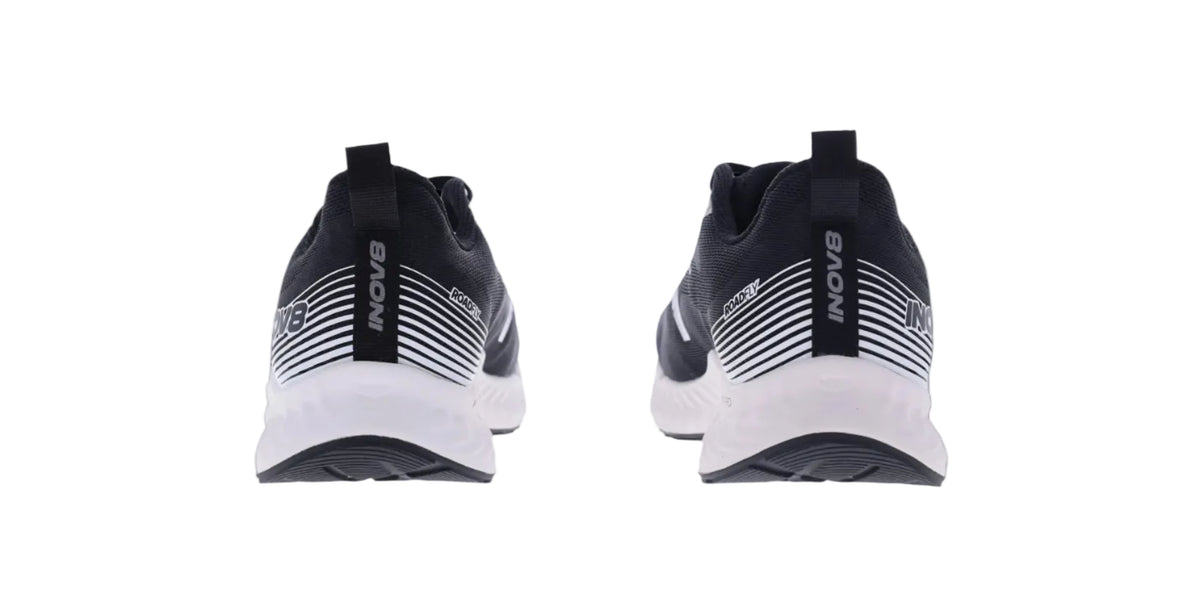 Pair of Inov8 RoadFly men's road running shoes in black and white, back view of heels with pull tabs