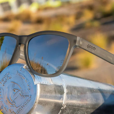 Goodr Going to Valhalla... Witness! grey sunglasses resting on a metal drink bottle in desert sunlight
