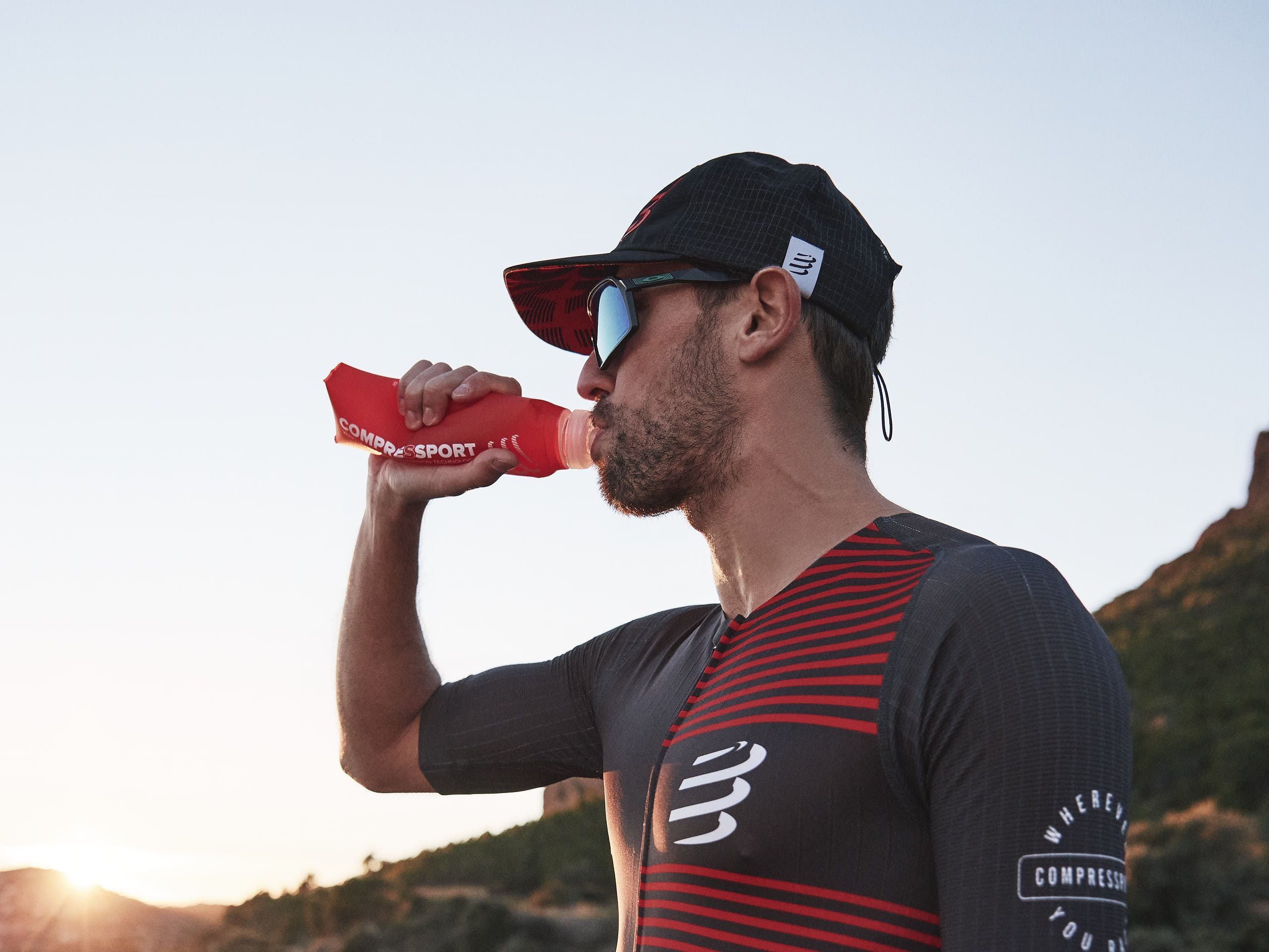 Racing Trucker Cap by Compressport in black and red, lightweight breathable headwear designed for racing athletes and outdoor style