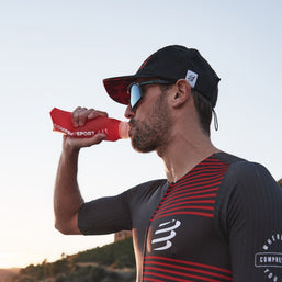 Racing Trucker Cap by Compressport in black and red, lightweight breathable headwear designed for racing athletes and outdoor style
