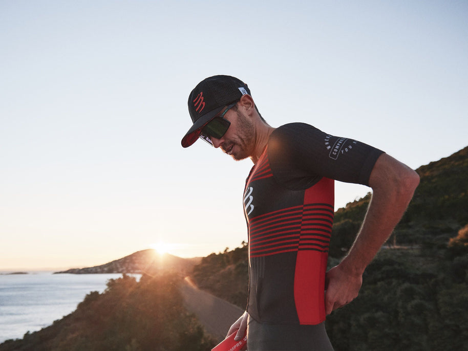 Racing Trucker Cap by Compressport in black with red logo, high-performance breathable headwear for stylish running and outdoor use